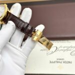 Rolex Perpetual 1908 beyaz kadranlı Super Clone saat – sarı kasa, kahverengi deri kayış ve PPF üretimi mekanizma.